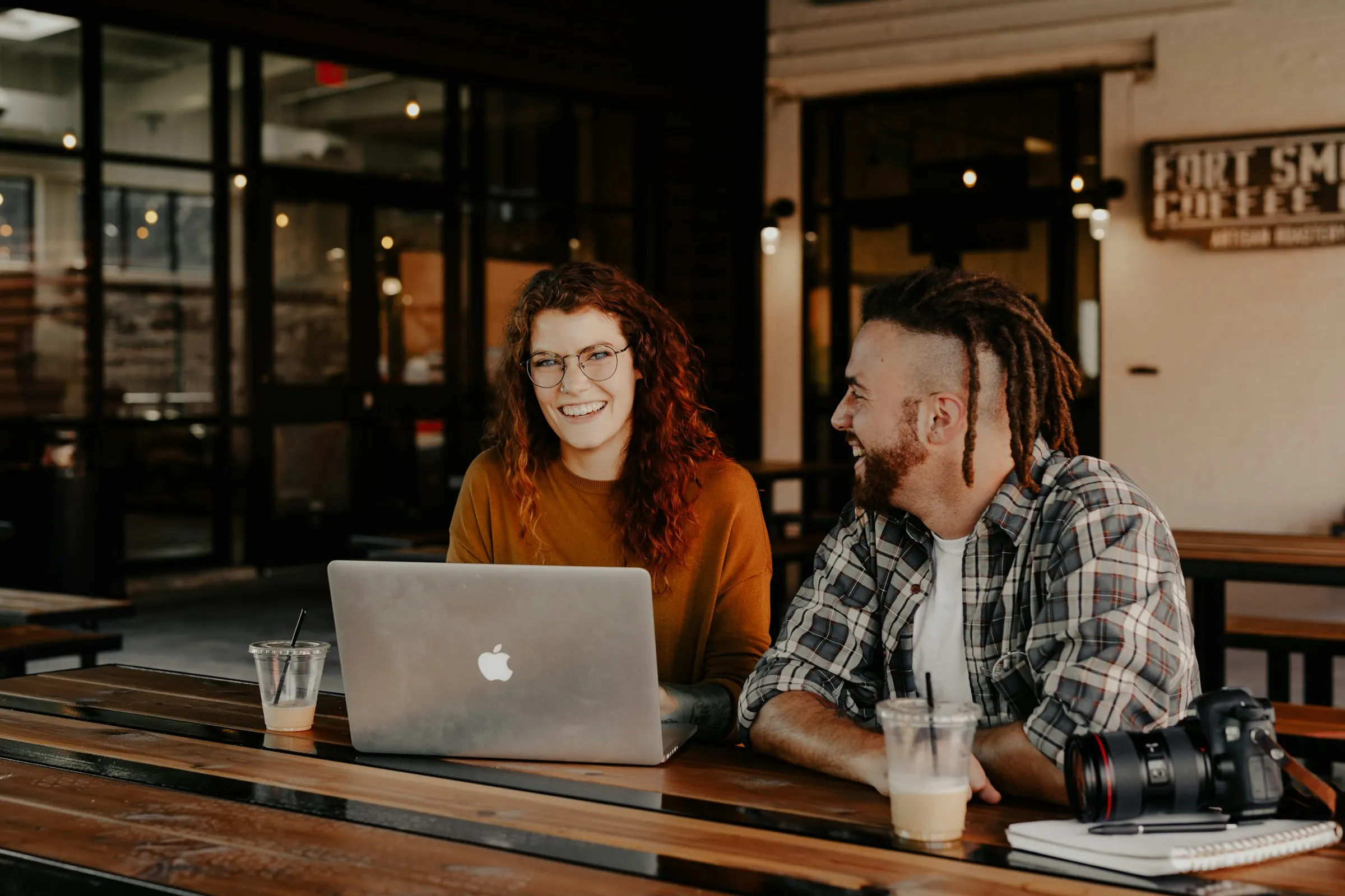 Two people planning a move over a laptop at a cafe